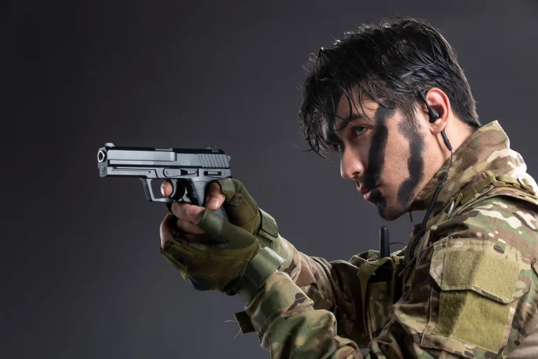 portrait-young-soldier-camouflage-aiming-gun-dark-wall